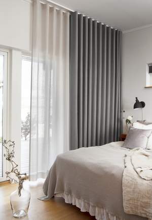 Dubbla gardiner i sovrummet, en mörkläggande och en genomsiktlig